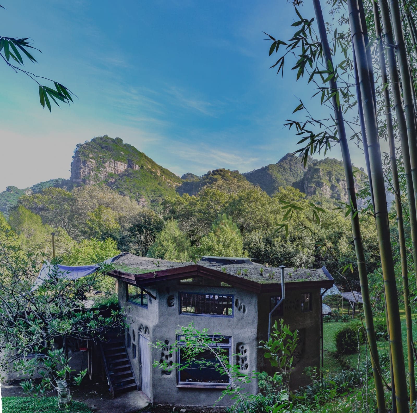Casa de bioconstrucción con techo verde frente a las montañas de Chalmita